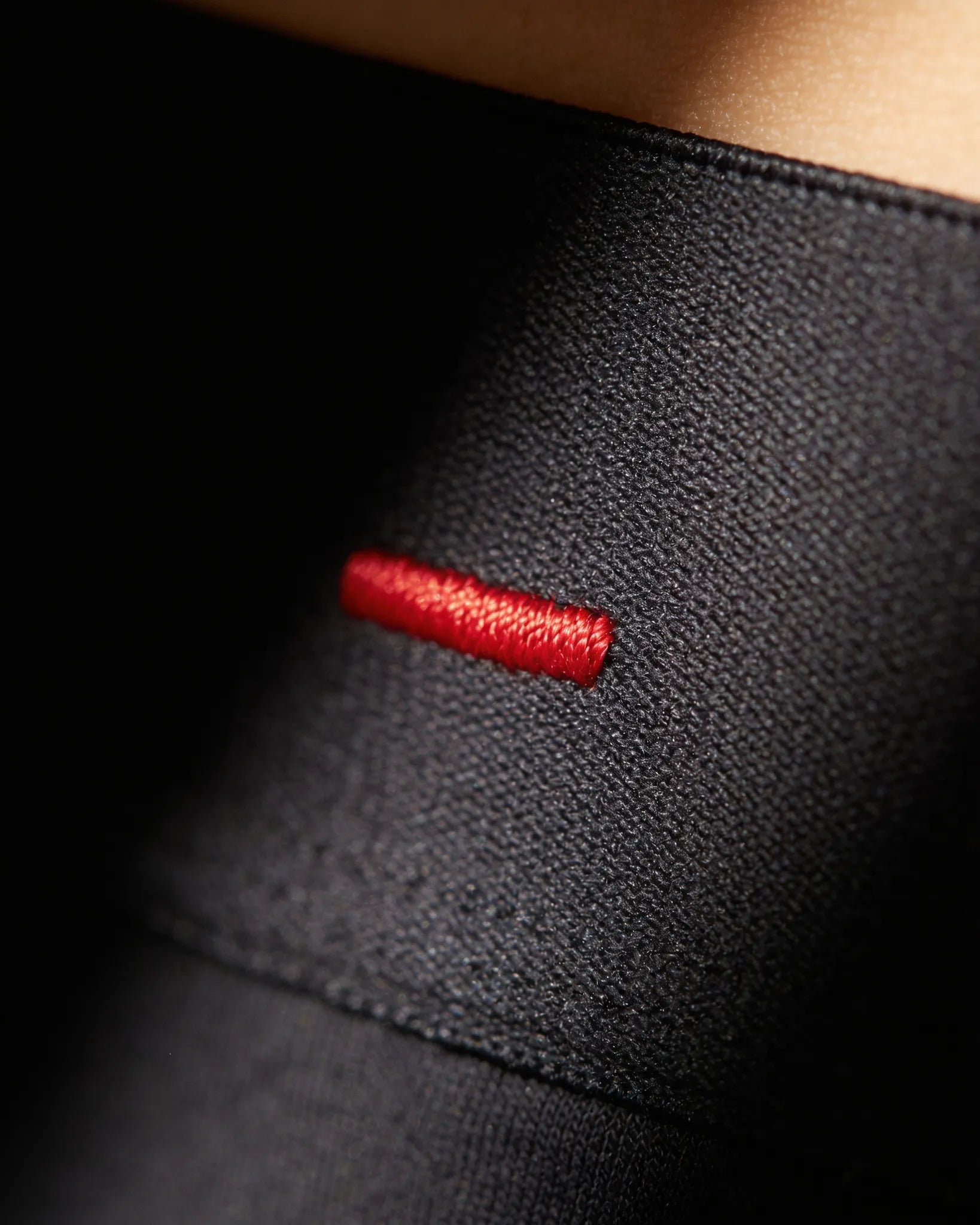 The single Fire Red bar-tack on an ātem waistband